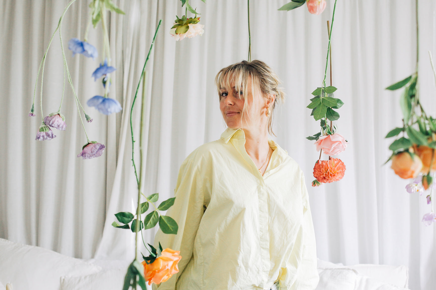 Abby stands amongst faux flowers Tussie